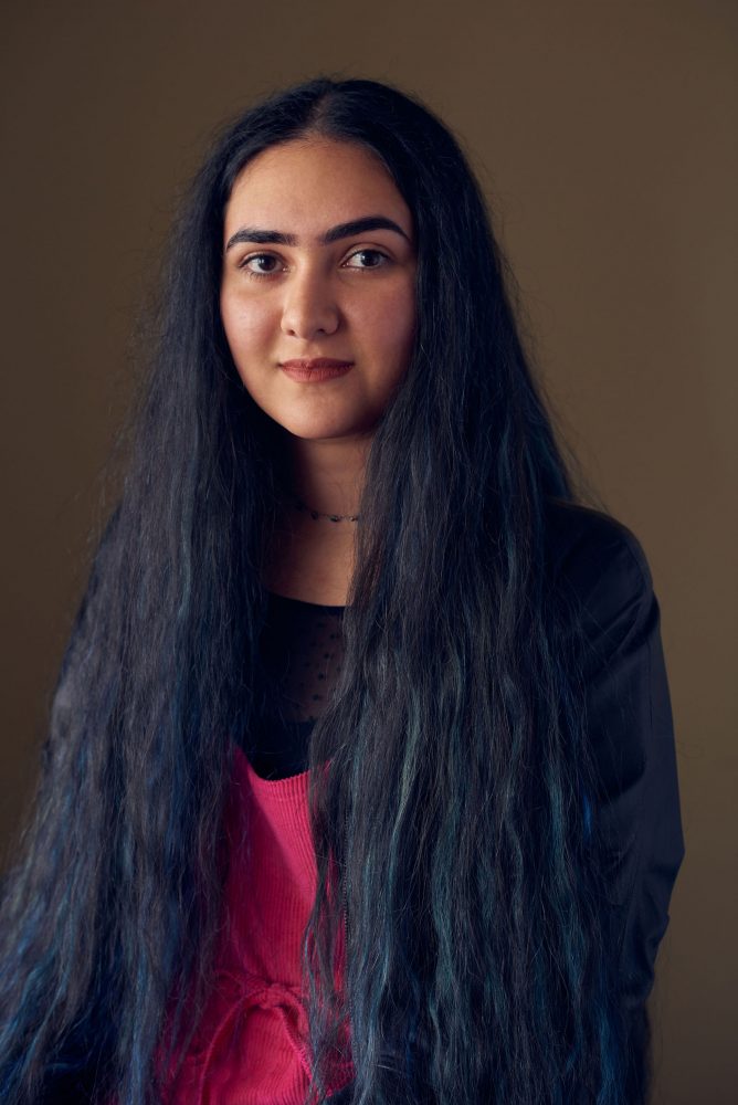 A portrait of Baran Rostamian. She is smiling at the camera. Her hair is very long and she has it down on her shoulders.