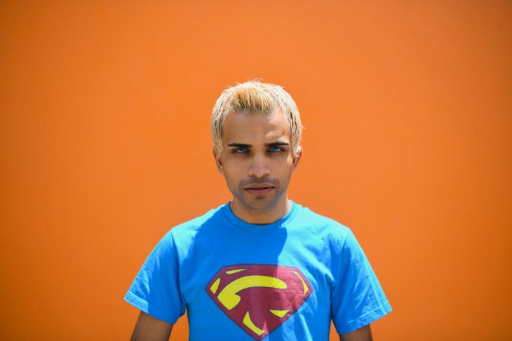 A bright portrait of Raphael Farmer. He is wearing a superman t-shirt and is looking straight into the camera.