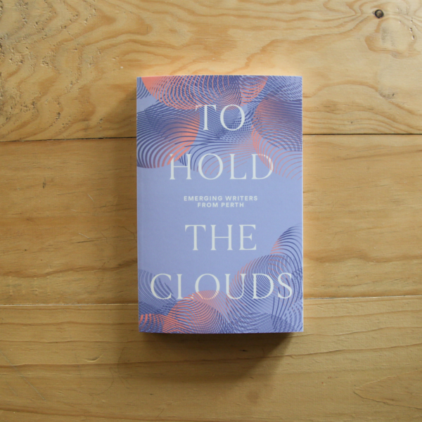 A photograph of a book sitting on top of a light wood table top. The book cover is a soft pastel purple with pink and dark purple cloud patterns layered over each other. The title reads TO HOLD THE CLOUDS in bold white.