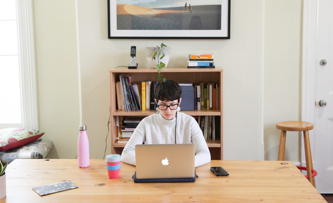 Photo of Luisa Mitchell sitting at a desk on her laptop